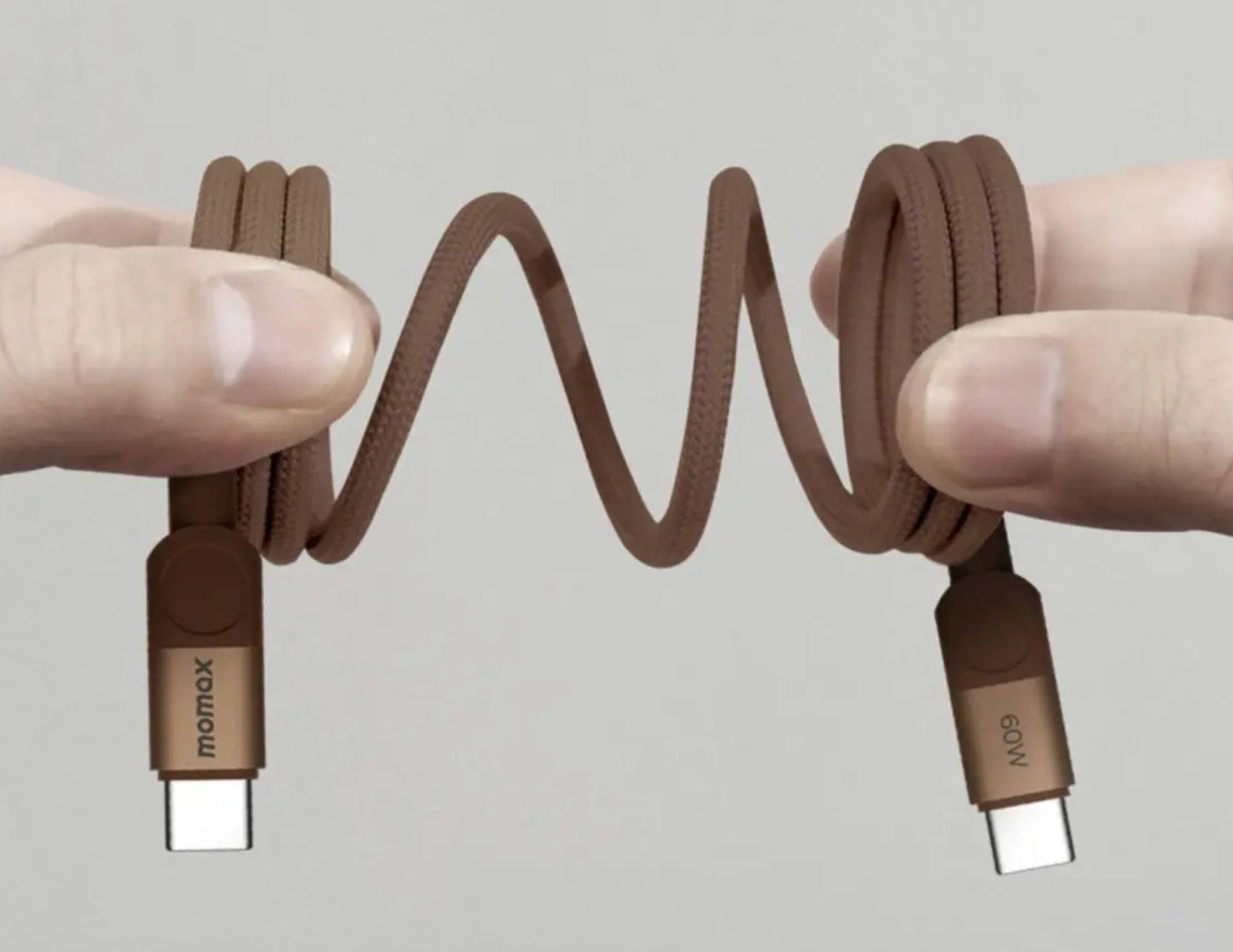 Brown braided cable with 'momax' branding held by two hands against a gray background