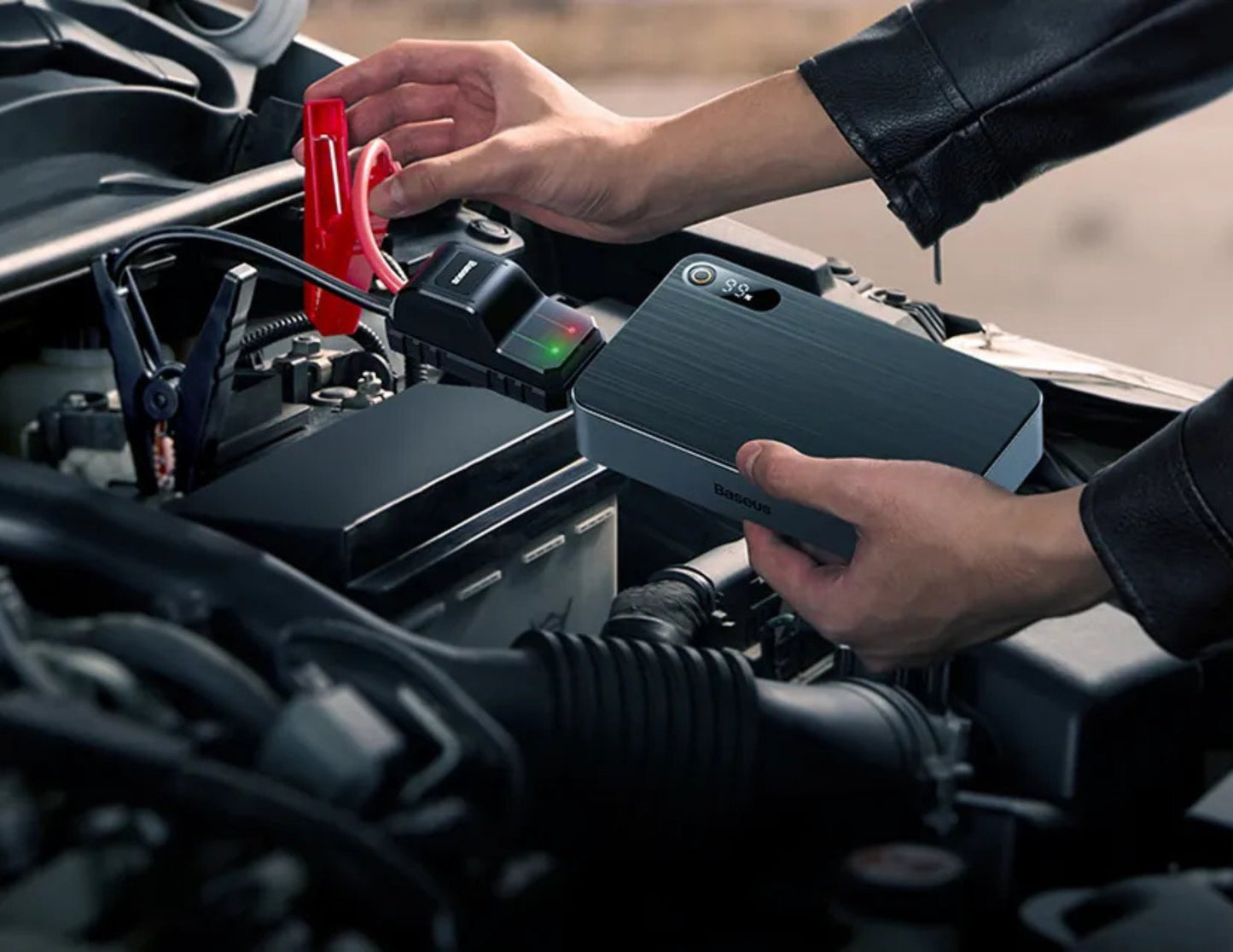 Person using a portable jump starter to charge a car battery