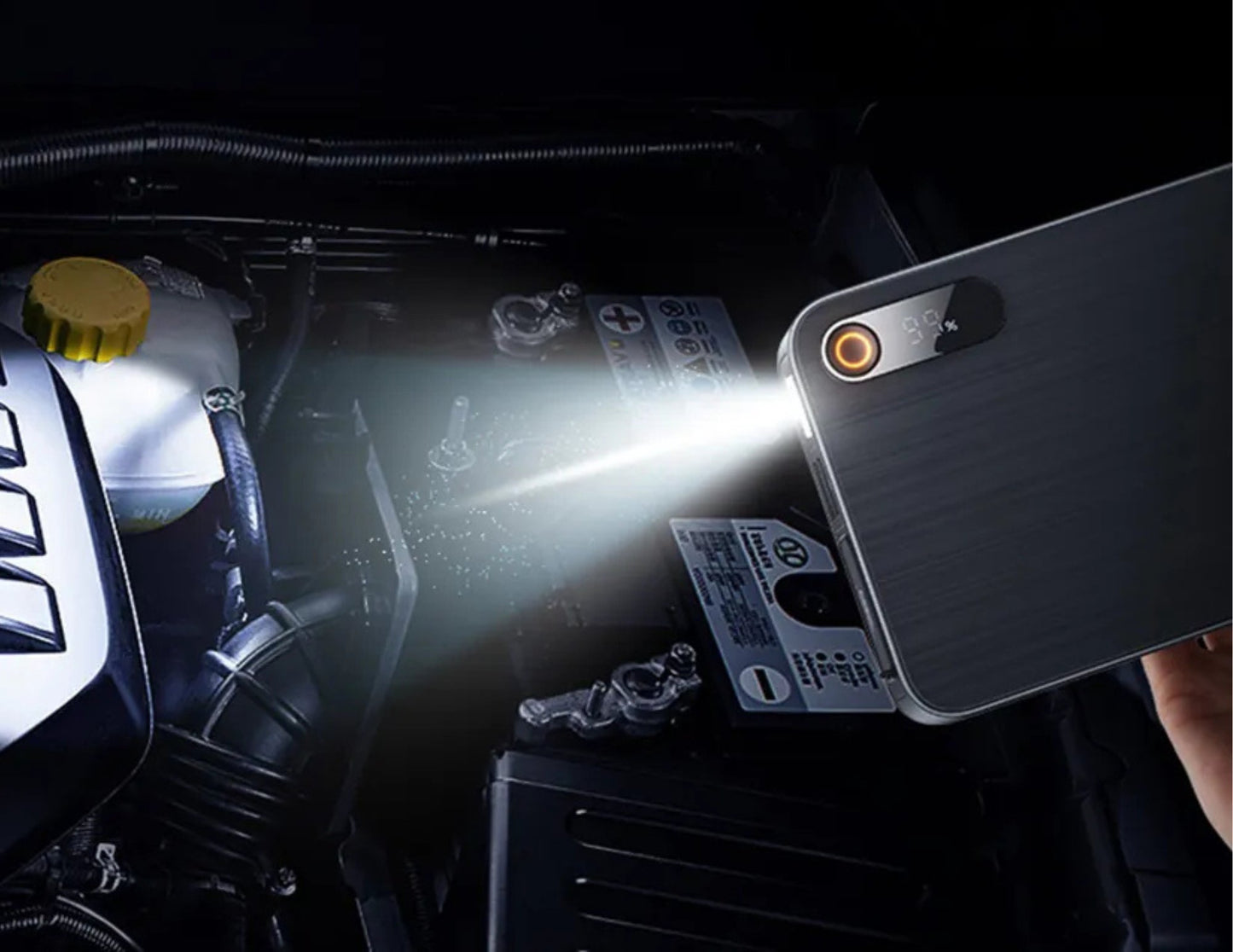 Phone with flashlight app illuminating car engine