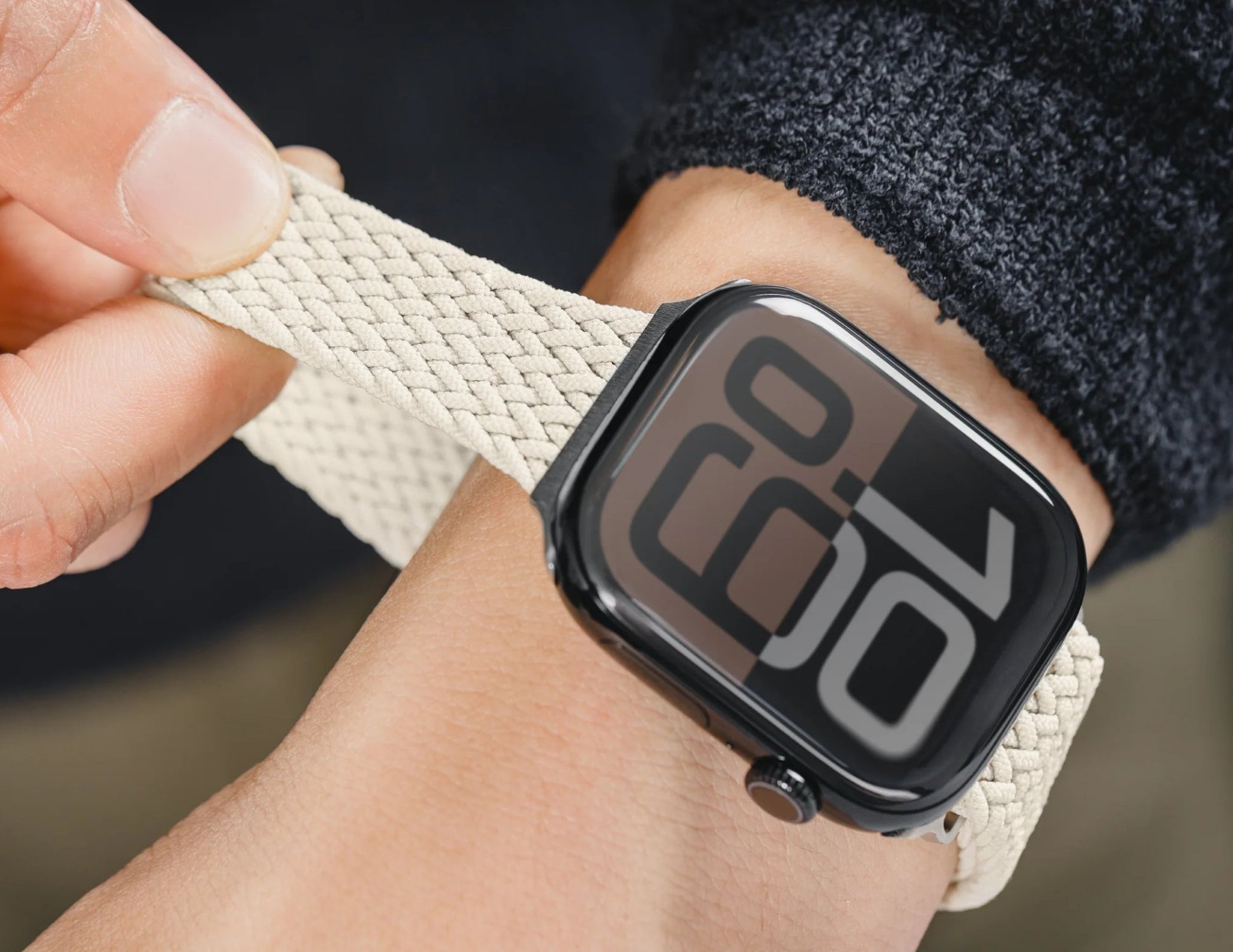 Digital watch with beige strap on wrist