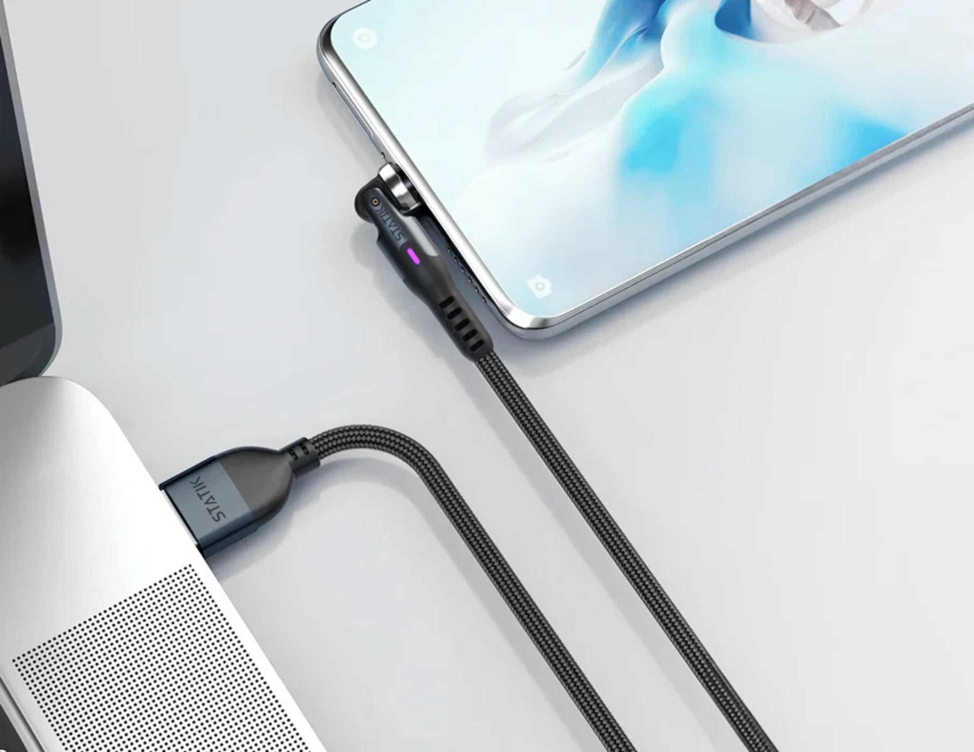 Phone and laptop connected by a cable on a light gray background