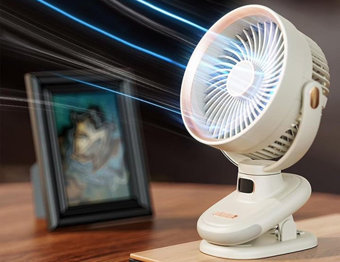 White clip-on fan on a wooden surface with a blurred background