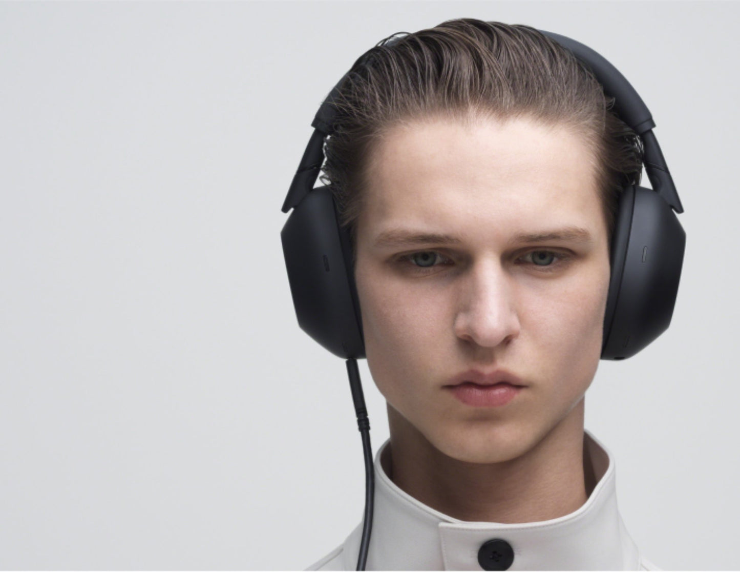 Person wearing large Sony WH-1000XM6 Wireless Noise Canceling Headphones – Black on a light gray background
