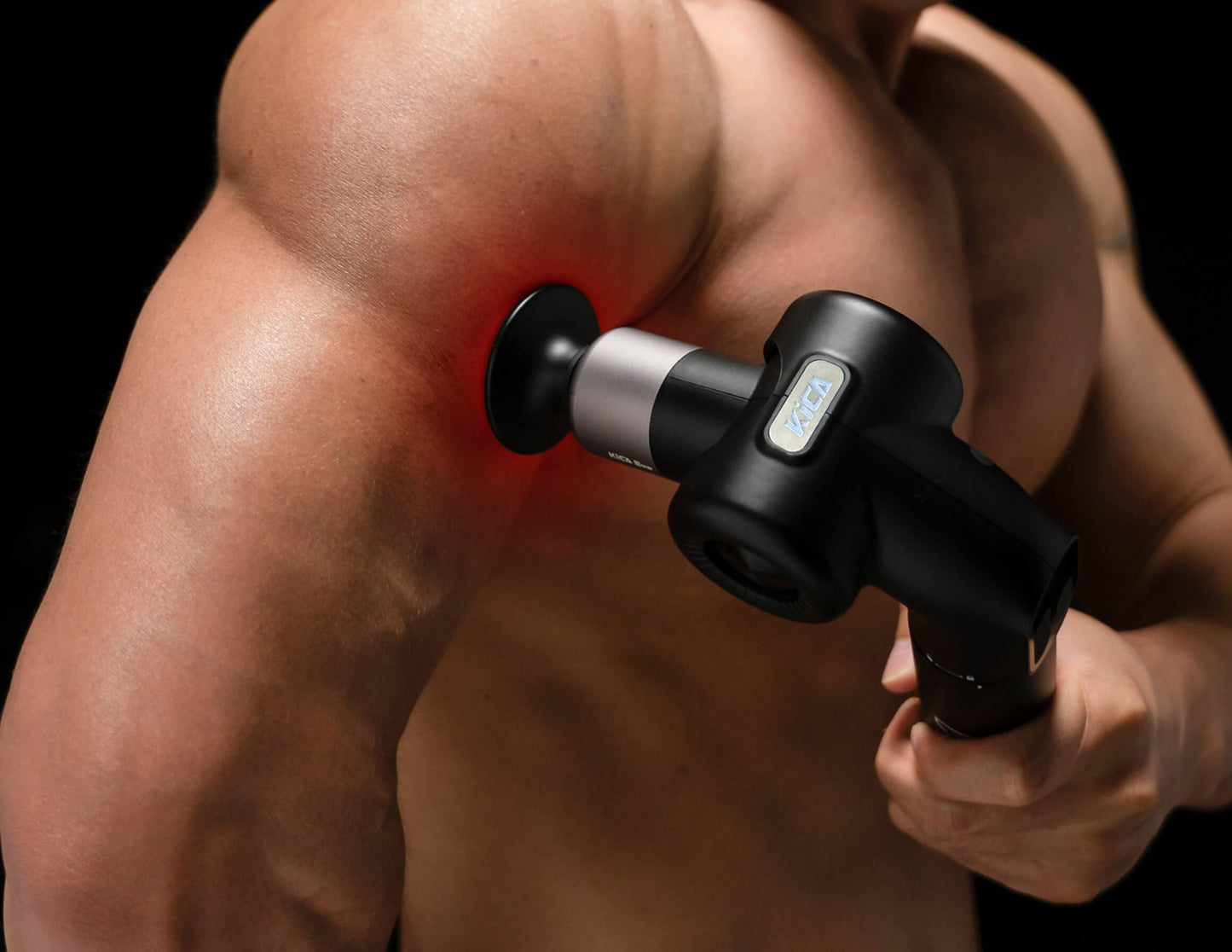 Person using a Kica Evo Fascia Massage Gun on their shoulder against a black background