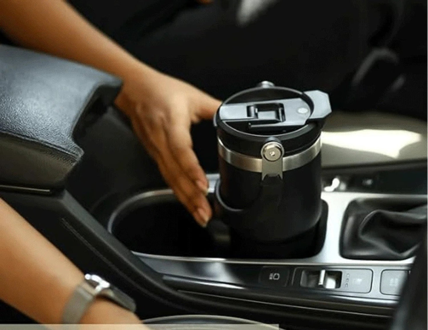 Person placing a black Tyeso TS-8828 Vacuum Insulated Tumbler 900ML in a car cup holder.