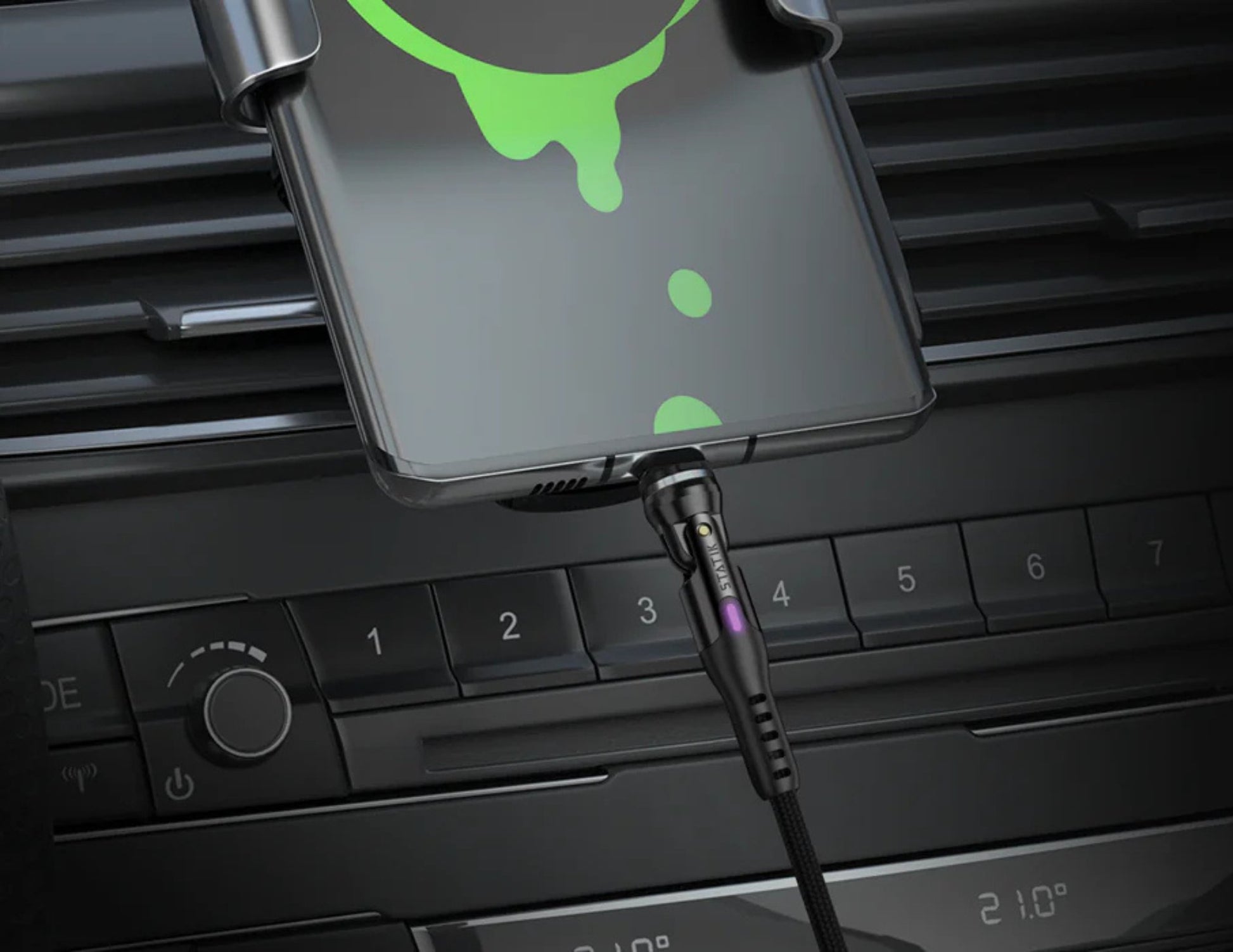 Phone case with green accents attached to a car vent, charging cable visible.