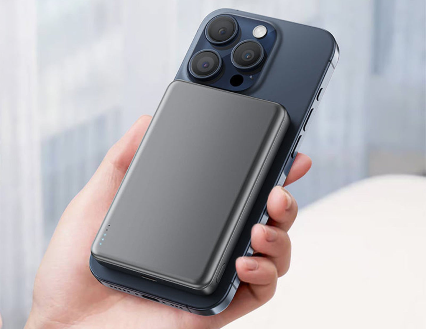 Person holding a smartphone with a Acefast M12 10000mAh Power Bank on a blurred background