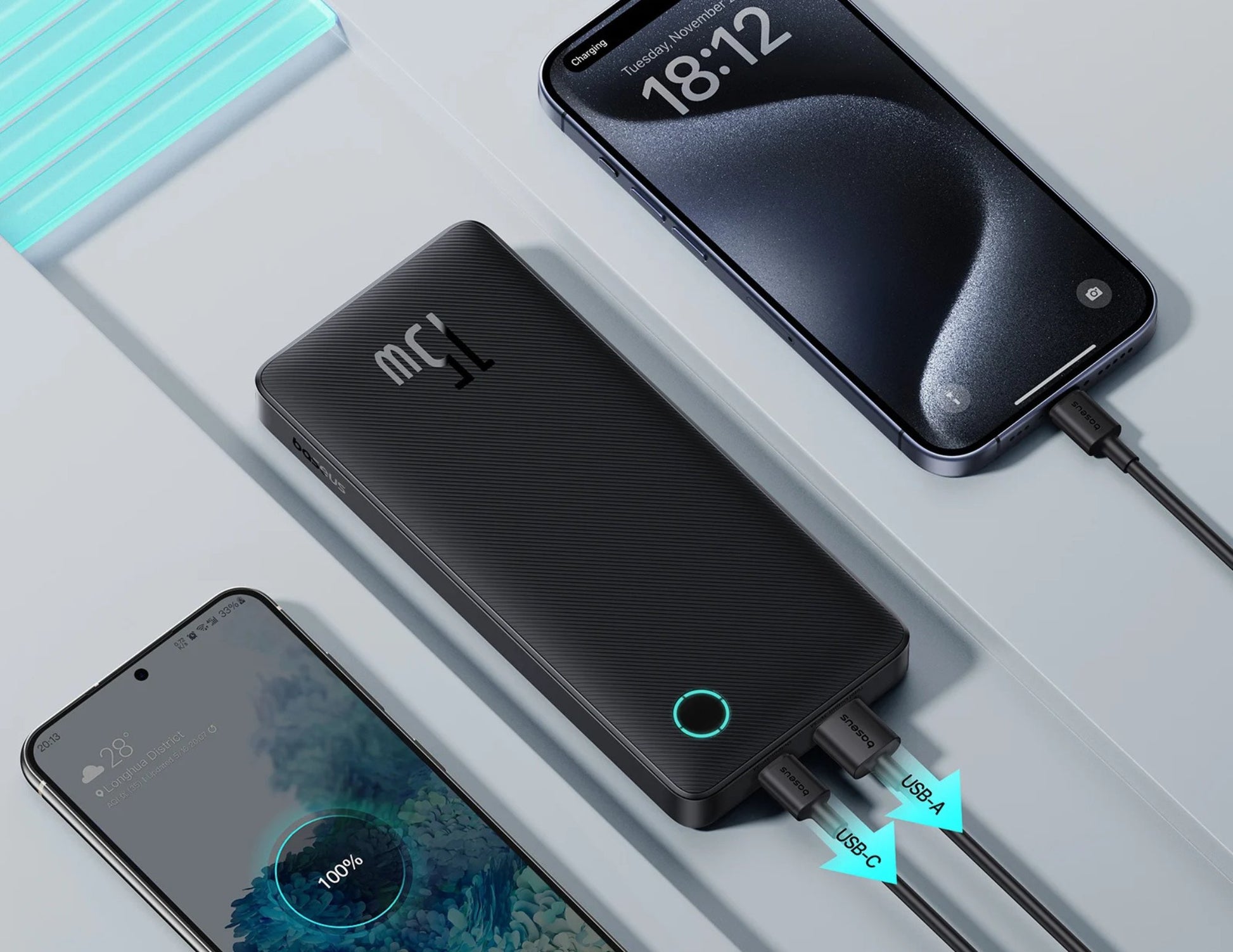 Black power bank with digital display connected to a smartphone on a light gray surface.