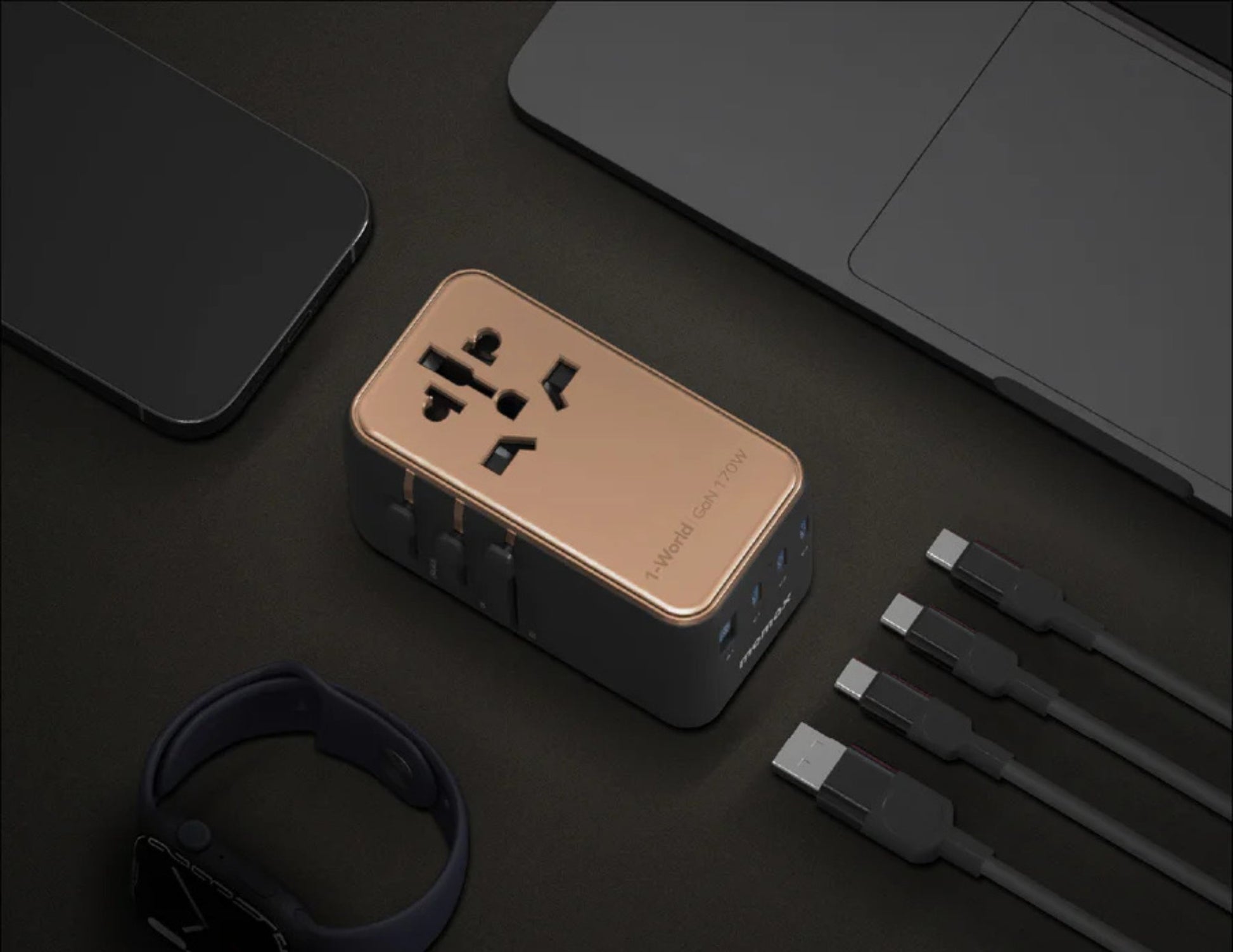 Travel adapter with multiple ports on a dark surface with cables and a watch.
