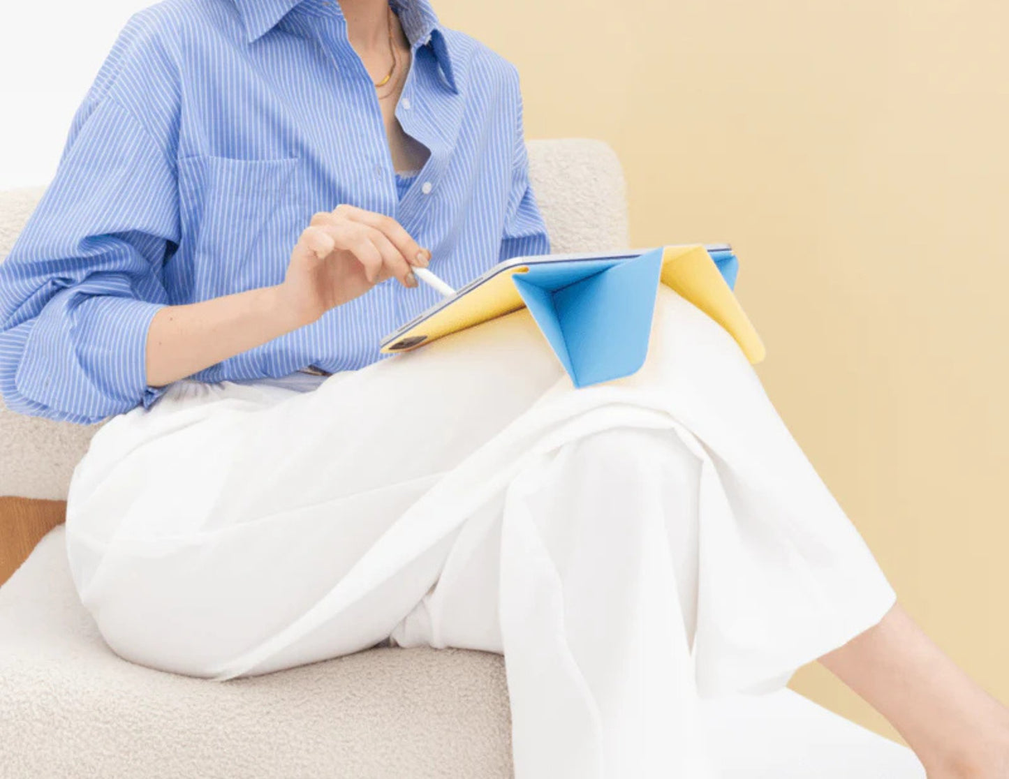 Person sitting on a couch holding a tablet with Moft Dynamic Folio Case for iPad Pro 13-inch (M4).