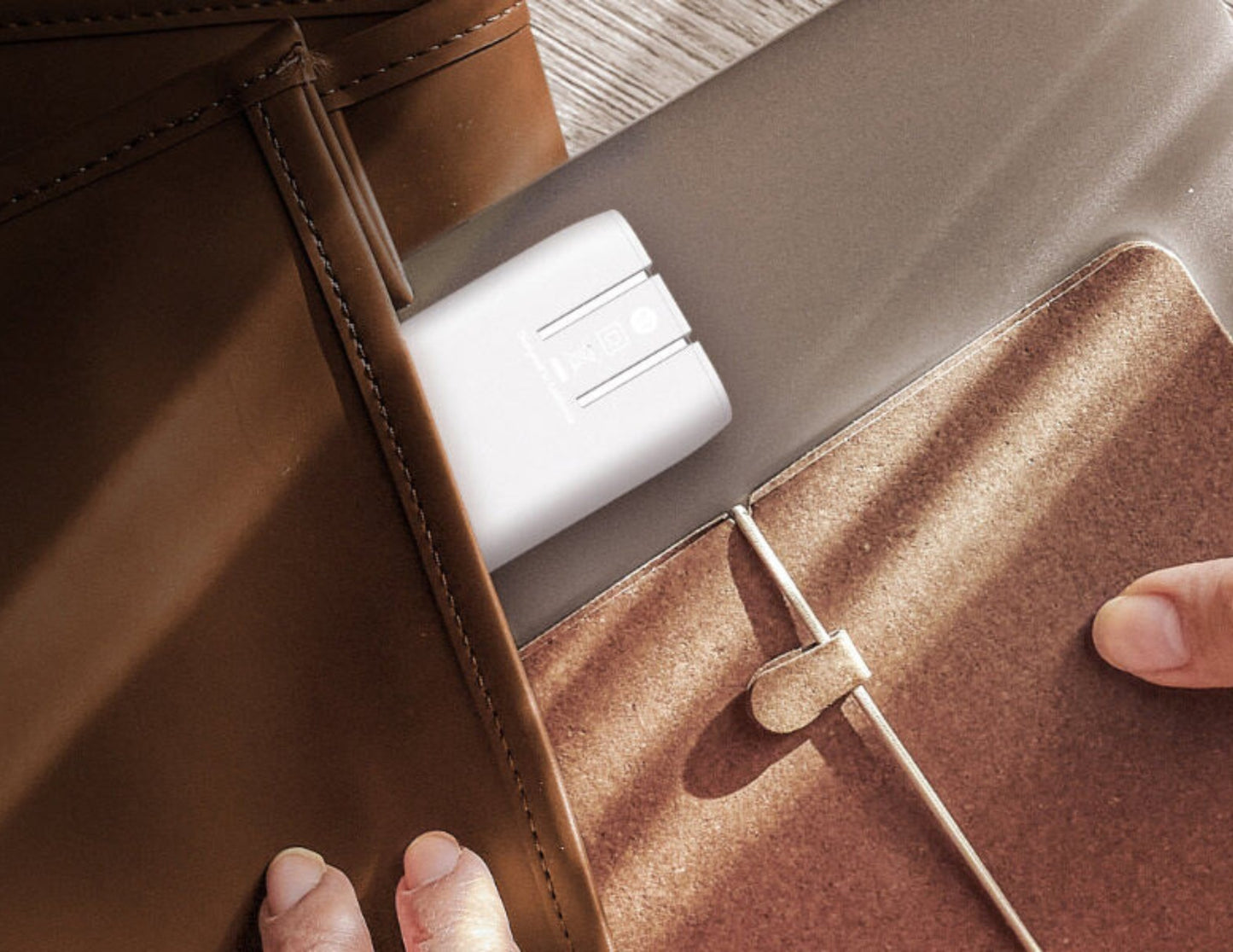 Close-up of a leather bag with a Belkin BoostCharge 3-Port USB-C® Wall Charger with PPS 67W + USB-C Cable – WCC002my2MWH-B6