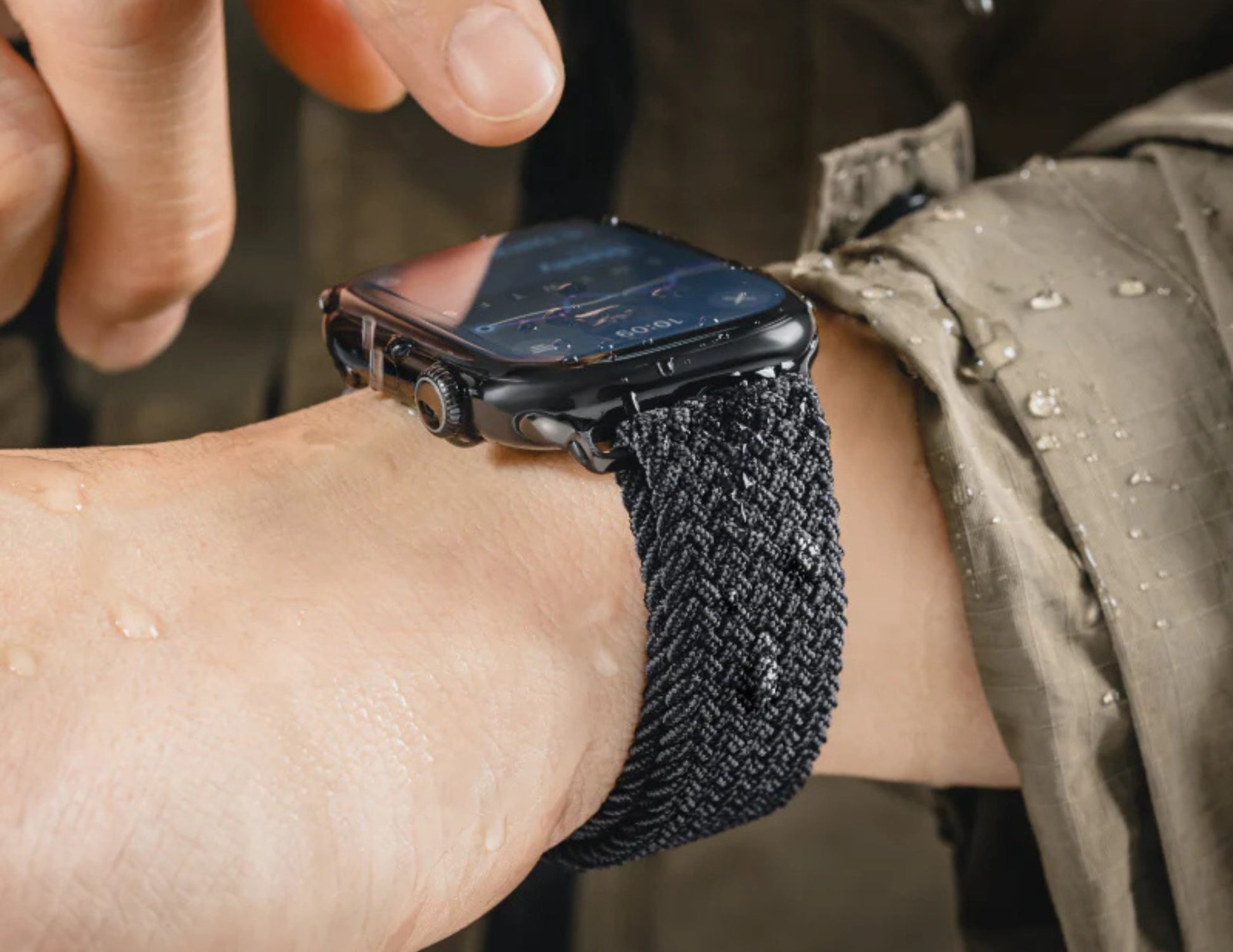 Smartwatch with black textured band on wrist.