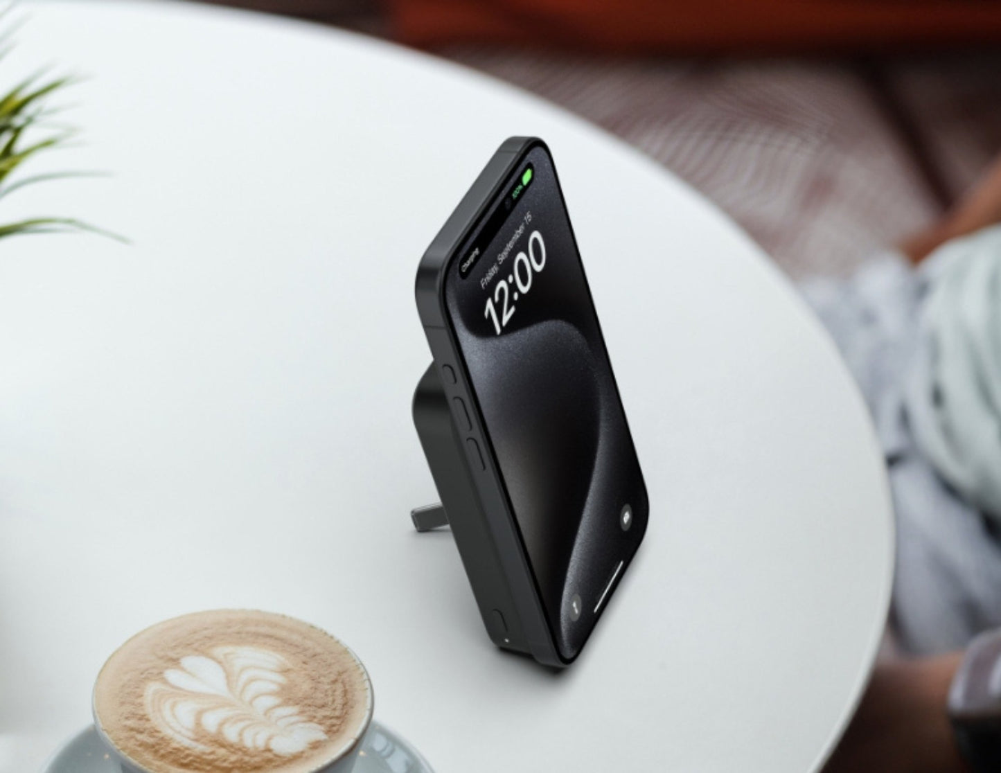 Belkin BoostCharge Pro Magnetic Wireless Power Bank 15W 8K+ BPD007btBK on a white table next to a cup of coffee.