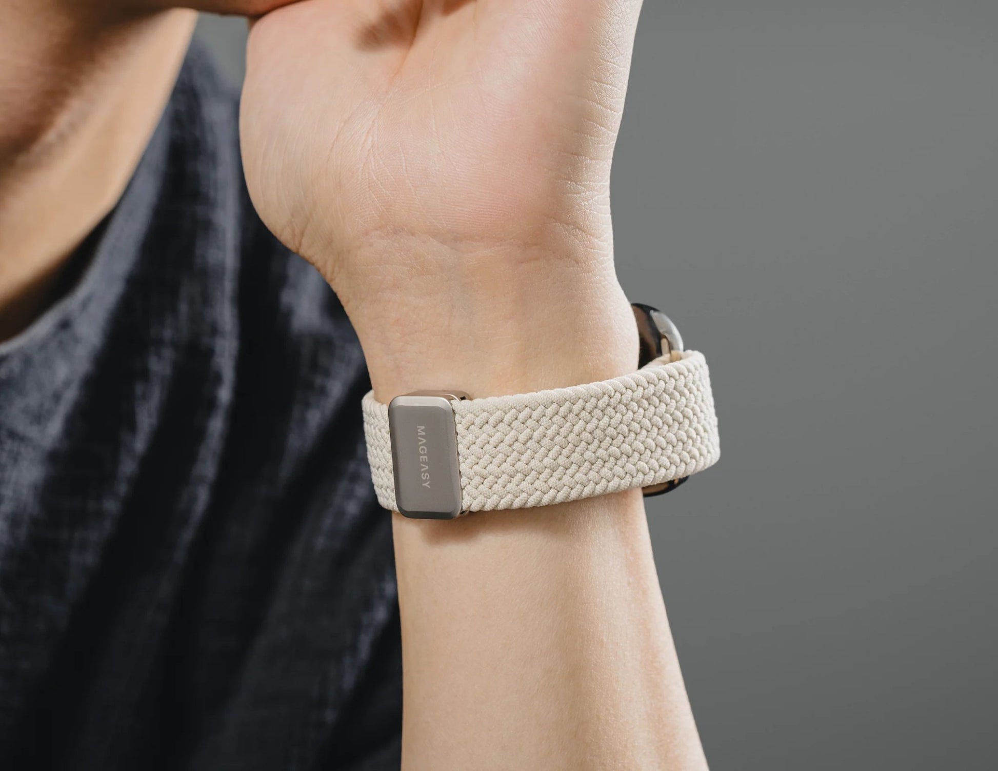 Close-up of a wrist with a beige woven fitness tracker.