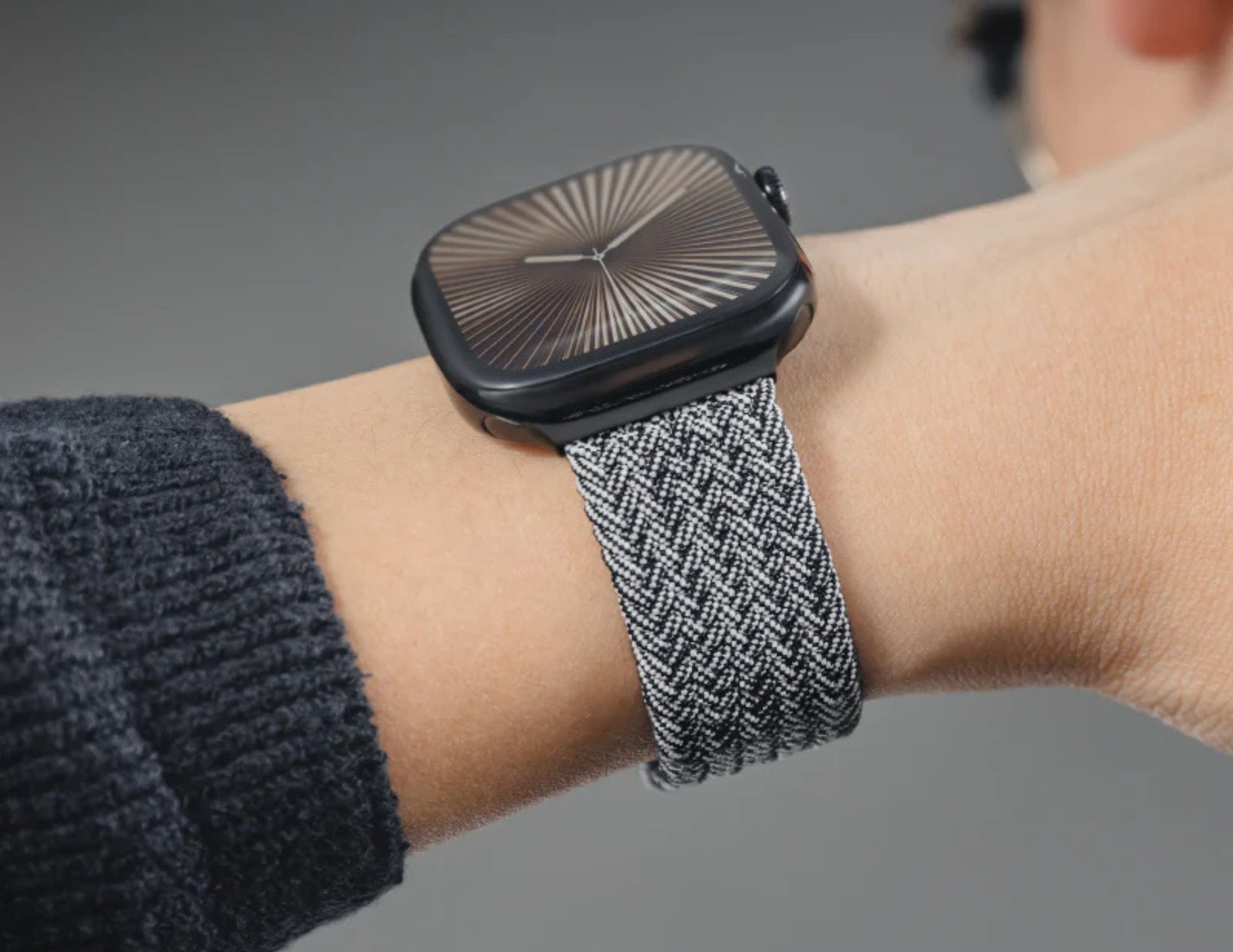 Smartwatch with a textured band on a person's wrist.
