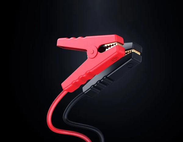Red and black alligator clip with a black background