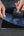 Person applying a screen protector to a device on a dark surface.