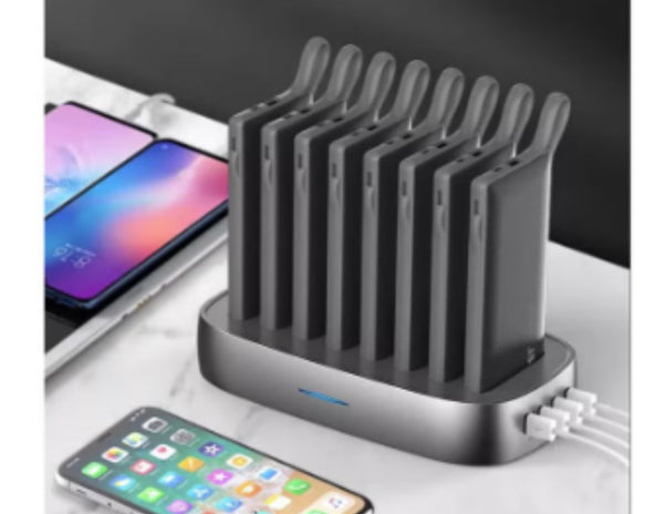 Black charging station with multiple ports charging multiple devices.