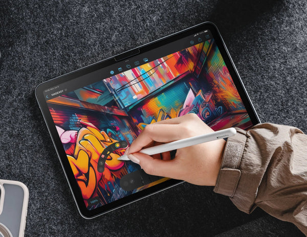 Person drawing colorful graffiti on a tablet with a stylus.