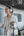 Woman wearing headphones and holding a phone at a train station