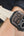 Digital watch with beige strap on wrist