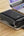Phone with a Acefast M4 20000mAh Power Bank attached on a wooden surface next to a laptop.