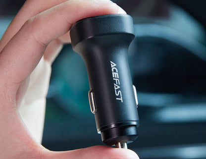 Hand holding a black car charger with 'ACEFAST' branding against a blurred background