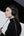 Woman wearing Sony WH-1000XM6 Wireless Noise Canceling Headphones – Black holding a black umbrella against a white background