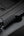 Coiled USB-C cable connected to a phone on a dark surface