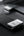 Phone with a USB-C adapter connected to a laptop on a dark surface