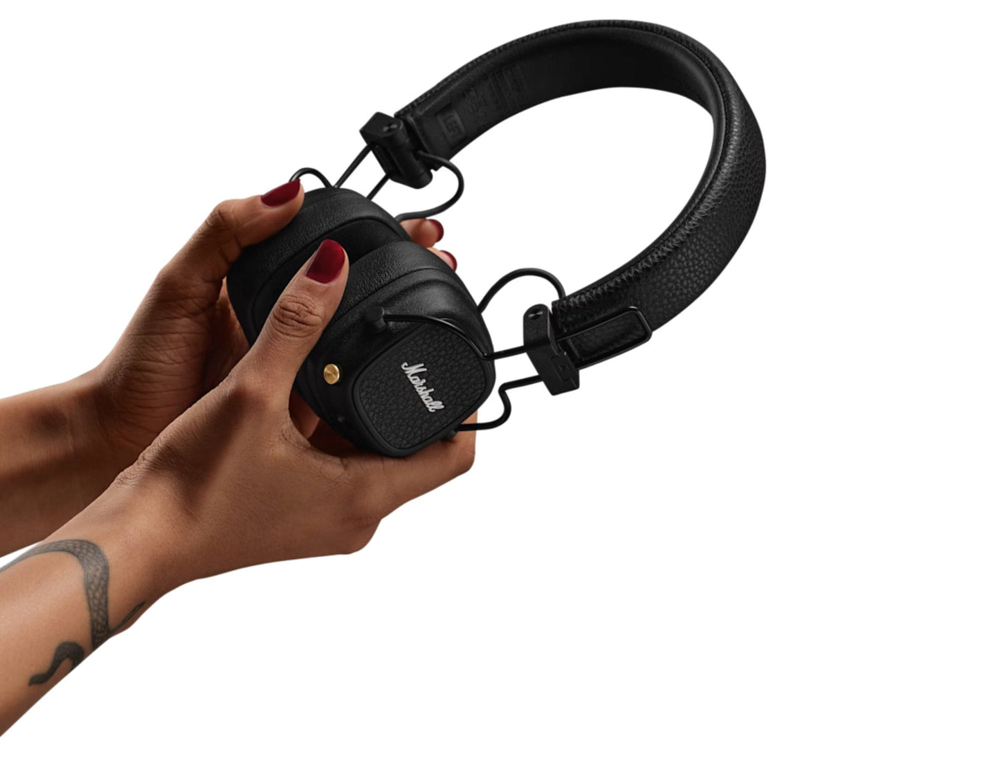 Black headphones held by a hand on a white background
