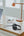 Laptop, headphones, and desk lamp connected to BELKIN BoostCharge Pro 108W 4-Port GaN Charger with 2 USB-C & 2 USB-A Ports – WCH010myWH on a wooden desk with a window in the background