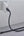 Black cable plugged into a white wall socket on a light gray surface.