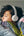 Person wearing headphones and wrapped in a colorful blanket on a couch