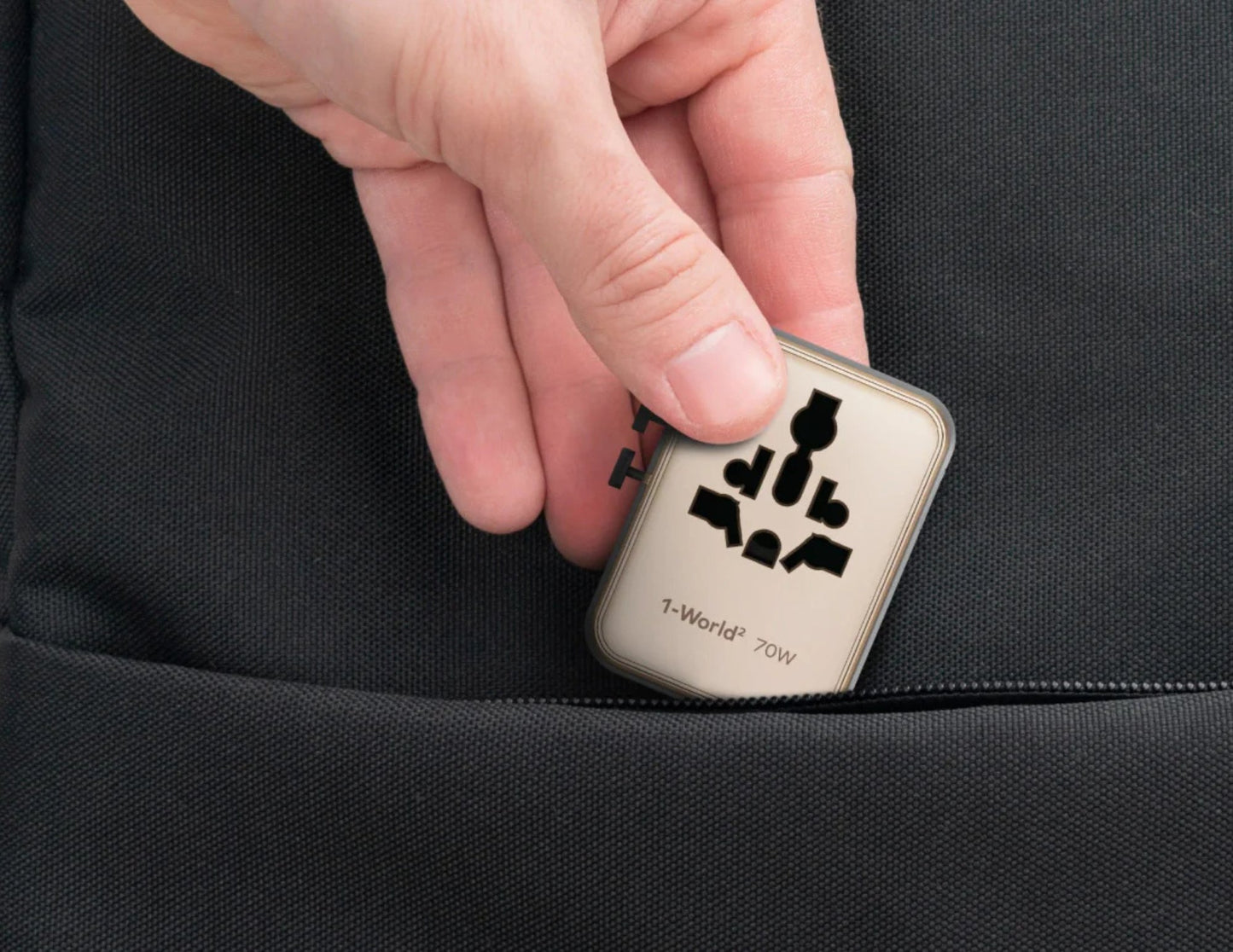 Momax 1‑World² 5‑Port Mini Universal Travel GaN Charger 70W with Dual AC – UA22L2 with '1-World' branding being placed into a black pocket.