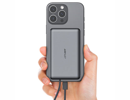 Hand holding a phone with a power bank attached on a white background