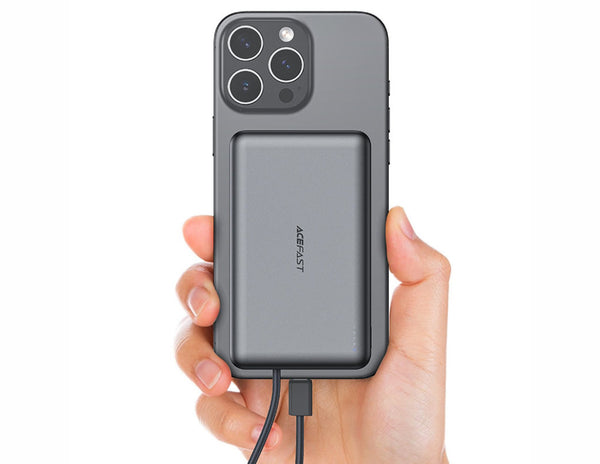 Hand holding a phone with a power bank attached on a white background