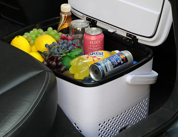 Portable cooler with drinks and snacks in a car trunk