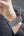 Person wearing a textured gray smartwatch on their wrist.