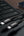 A black APELFast cable on a laptop keyboard with a smartphone in the background.