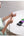 Woman using a smartphone with a Baseus Compact Fast Charging Power Bank iP Edition on a table.