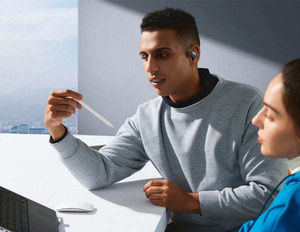 Two people sitting at a desk with a laptop, one holding a straw and wearing Baseus Eli Sport 1 Open-Ear TWS Earbuds A00064400121-00 Black