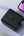 Black charging adapter with UK plug on a light gray background