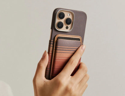 Hand holding a phone with a Pitaka MagSafe Woven Wallet – Magsafe Compatible MWW240 against a neutral background