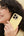 Woman holding a yellow phone case against a beige and blue background