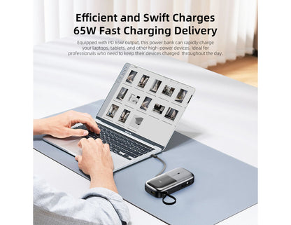 Person using a laptop with a Vyvylabs Power Lite Digital Display Power Bank 20000mAh 65W with C+L Fast Charging Cable – VBQ08-TN on a desk, emphasizing fast charging capability.