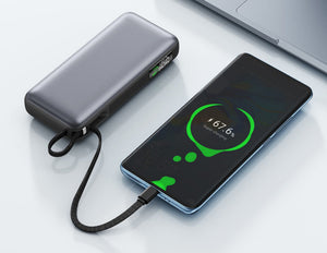 Phone being charged by a power bank on a white surface