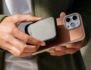 Person holding a phone with a case on, showing the brand 'UNIQ'.