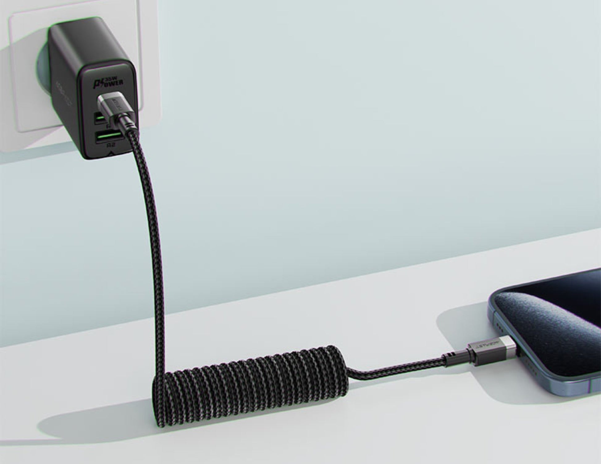Phone charger with coiled cable on a white surface
