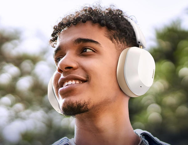 Man wearing white headphones with a blurred outdoor background